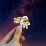 Dogecoin astronaut sticker holding doge astronaut sticker in hand