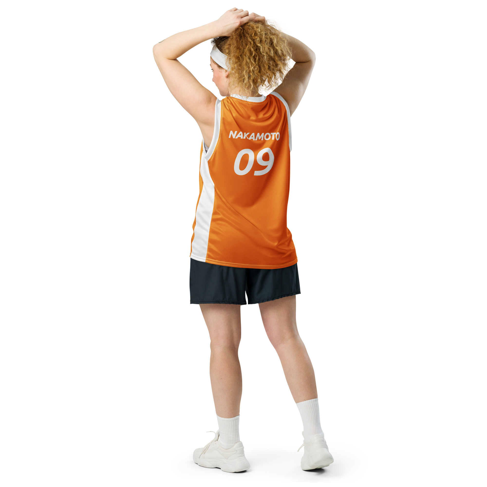 Back side view of a Female wearing the Bitcoin Basketball Jersey with cargo pants. The Jersey features "Nakamoto" across the top and the year 09, the year bitcoin was created in 2009. The lettering is in bitcoin font Ubuntu bold italic.