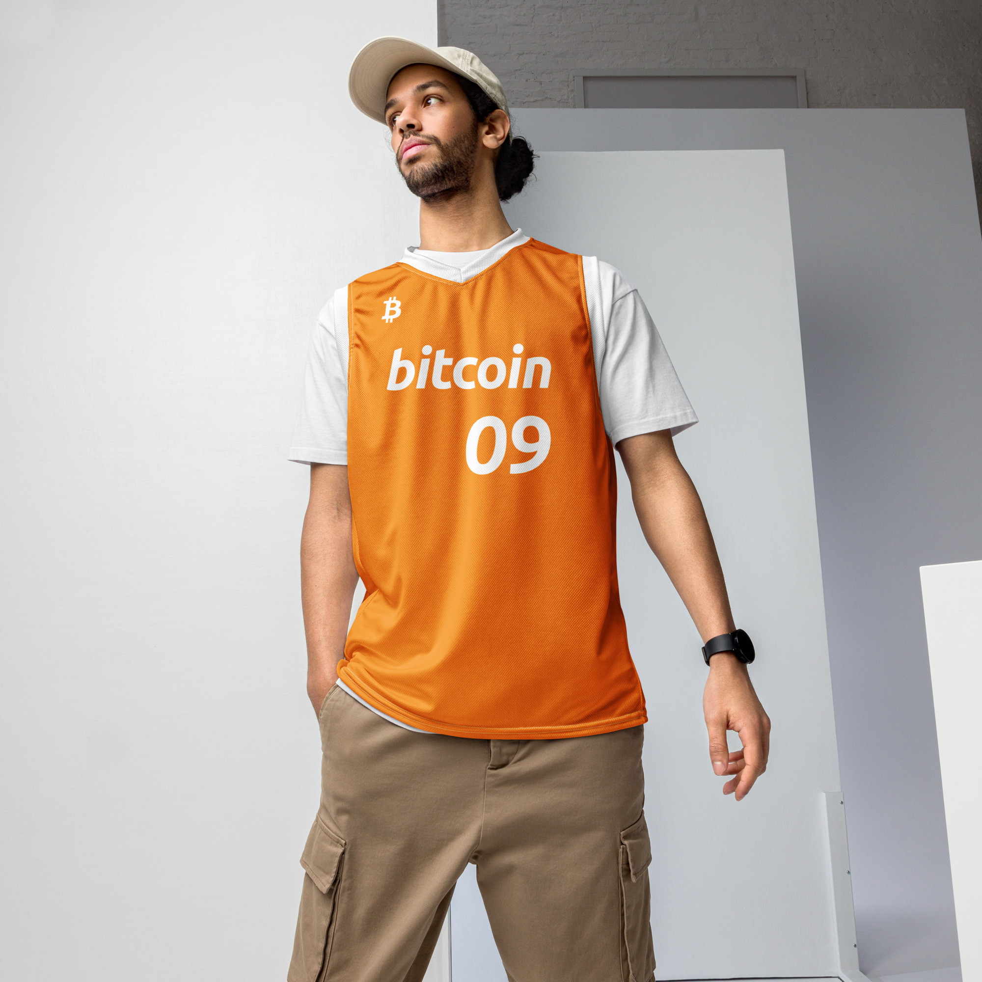 Front view of a Male wearing the Bitcoin Basketball Jersey with cargo pants. The Jersey features the Bitcoin icon in the top right chest, the Bitcoin logo and the number 09 to represent the year Bitcoin was created. The lettering is in bitcoin font Ubuntu bold italic.
