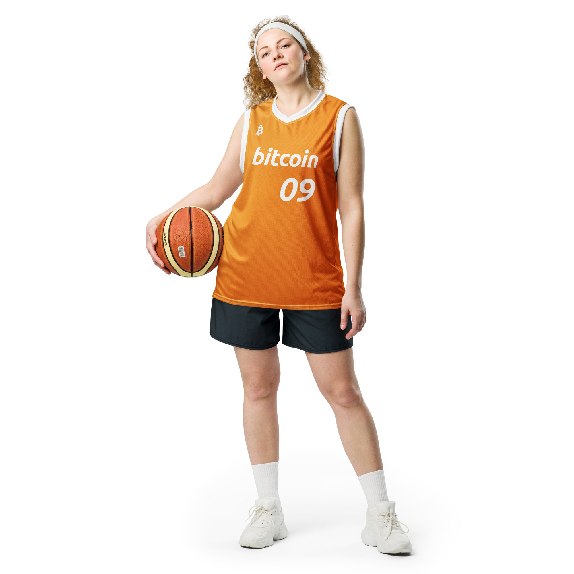 Front view of a Female wearing the Bitcoin Basketball Jersey with cargo pants. The Jersey features the Bitcoin icon in the top right chest, the Bitcoin logo and the number 09 to represent the year Bitcoin was created. On a white background, holding a basketball. The lettering is in bitcoin font Ubuntu bold italic.